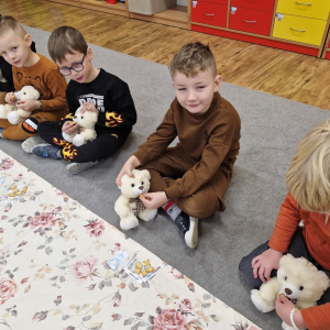 Chłopcy podają misiom ciasteczka