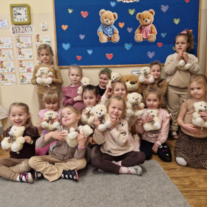 Dziewczynki z misiami na tle dekoracji związanej  Dniem Pluszowego Misia