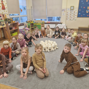 Dzieci siedzą w kole wokół pluszowych misiów