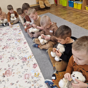 Chłopcy podają misiom ciasteczka