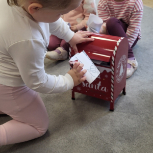 Dziewczynka wrzucająca list do skrzynki.