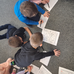 Dzieci wykonują zadanie na karcie pracy