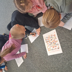 Dzieci wykonują zadanie na karcie pracy