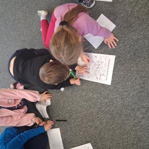 Dzieci wykonują zadanie na karcie pracy