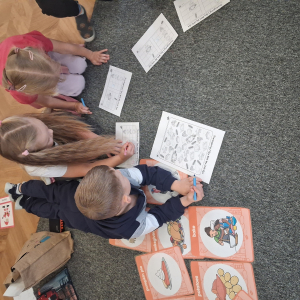 Dzieci wykonują zadanie na karcie pracy