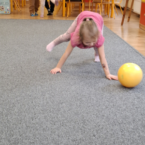 Dziewczynka toczy piłkę