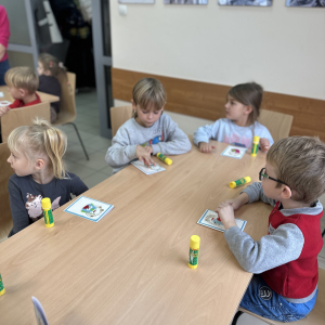 Wspólna praca: „Przedszkolaki pracują wspólnie przy stołach, wymieniając się pomysłami i inspiracjami.”