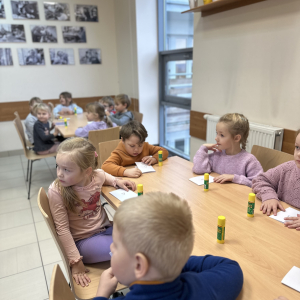 Wspólna praca: „Przedszkolaki pracują wspólnie przy stołach, wymieniając się pomysłami i inspiracjami.”