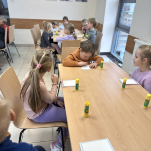 Wspólna praca: „Przedszkolaki pracują wspólnie przy stołach, wymieniając się pomysłami i inspiracjami.”