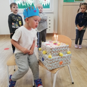 Wiktor zdmuchuje świeczki na torcie