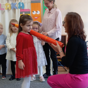 Pani dyrektor pasuje dziewczynkę na przedszkolaka