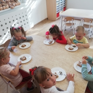Dzieci smakują ciasto jabłkowe oraz sok 