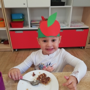 Dzieci smakują ciasto jabłkowe i sok