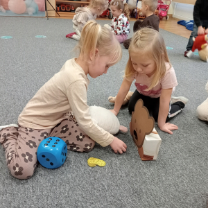 dziewczynki "karmiące" misia ciasteczkami zgodnie z wyrzuconą liczbę oczek na kostce