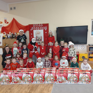 Dzieci pozujące do zdjęcia z świętym Mikołajem.