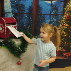 Dziewczynka wysyła list do Św. Mikołaja.