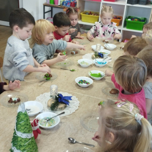 Dzieci ozdabiają i degustują pierniczki.