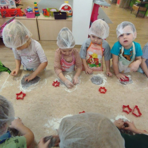 Dzieci wyrabiają ciasto i wykrawają pierniczki.