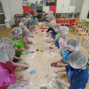 Dzieci wyrabiają ciasto i wykrawają pierniczki.