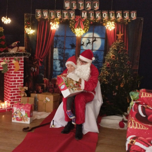 Dziecko odbiera prezenty od św. Mikołaja.