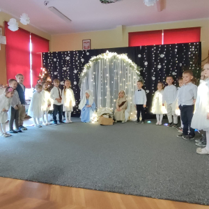 Podarunki dla Jezusa – dzieci symbolicznie wręczają Dzieciątku swoje prezenty, wyrażając miłość i radość.