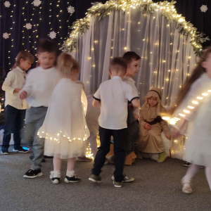 Podarunki dla Jezusa – dzieci symbolicznie wręczają Dzieciątku swoje prezenty, wyrażając miłość i radość.