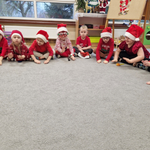 Dzieci naśladują stukot kopyt reniferów - uderzają dłońmi o dywan 
