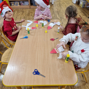 Dzieci w czasie zajęć plastycznych- wykonują pracę plastyczną "Mikołaj"