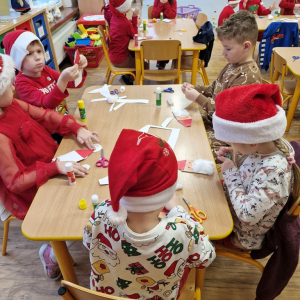 Dzieci w czasie zajęć plastycznych- wykonują pracę plastyczną "Mikołaj"