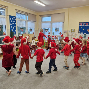 Dzieci chodzą w kole i śpiewają piosenkę o Mikołaju