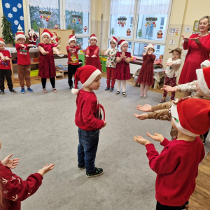 Dzieci wskazują na  chłopca będącego w zabawie Mikołajem