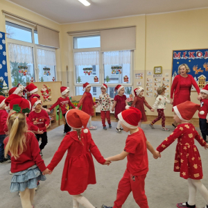 Dzieci chodzą w kole i śpiewają piosenkę o Mikołaju