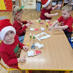 Dzieci w czasie zajęć plastycznych- wykonują pracę plastyczną "Mikołaj"