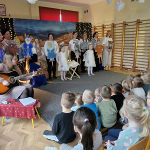 Aktorzy (Panie i dzieci) trzymając sylwety postaci , śpiewają piosenkę na zakończenie teatrzyku