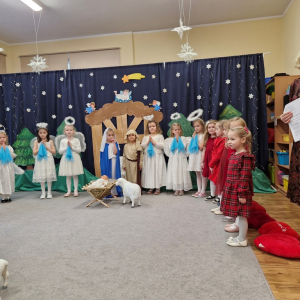 Dzieci na tle scenografii do jasełek tuż przed występem