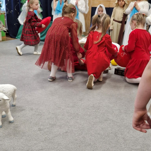 Dzieci kładą poduszeczki u stóp Dzieciątka Jezus