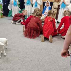 Dzieci kładą poduszeczki u stóp Dzieciątka Jezus