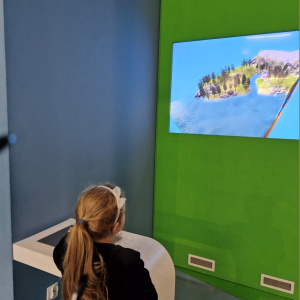 Dziewczynka obserwuje obieg wody w przyrodzie na tablicy interaktywnej