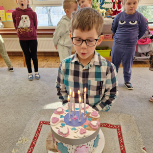 Chłopiec zdmuchuje świeczki