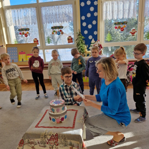 Wychowawczyni czyta życzenia  na urodzinowym dyplomie 