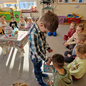 Chłopiec częstuje dzieci słodyczami