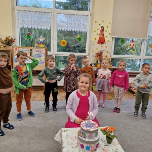 Solenizantka tuż przed zdmuchnięciem świeczek na urodzinowym torcie