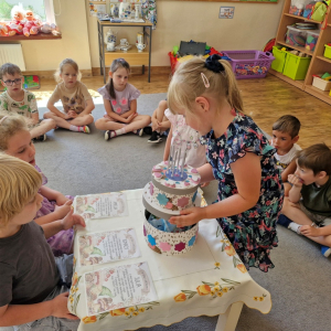 Dziewczynka otwiera tort, aby zobaczyć ukryte upominki - niespodzianki urodzinowe