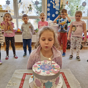 Solenizantka zdmuchuje świeczki na torcie