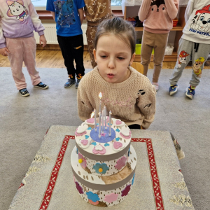 Dziewczynka zdmuchuje świeczki na torcie