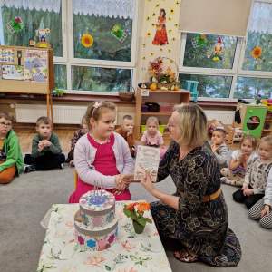 Pani Marysia wręcza dziewczynce dyplom z okazji 5 -tych urodzin