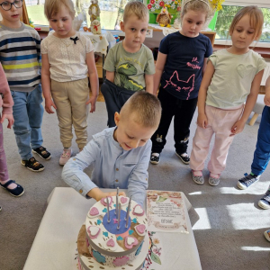 Chłopiec otwiera tort, by zobaczyć ukrytą niespodziankę  - upominek  z okazji urodzin