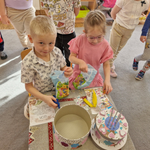 Dzieci oglądają upominki- niespodzianki  z okazji 6-tych urodzin