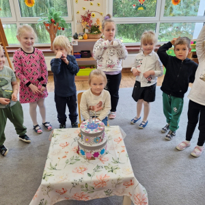 Dziewczynka z dziećmi  po zdmuchnięciu świeczek  na torcie z okazji swoich 5 -tych urodzin