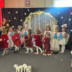 Dzieci idą z poduszeczkami w kształcie serca przy   śpiewie pastorałki  "Gdzie mieszkasz Jezu"